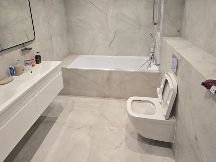 A bathroom fitted by GS Renovation with a panelled bath and a floating double vanity