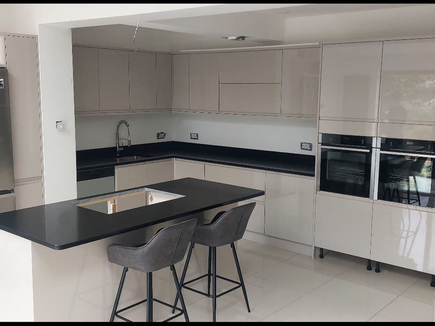 A handleless gloss kitchen part-way through installation by GS Renovation, with the worktop templated and set