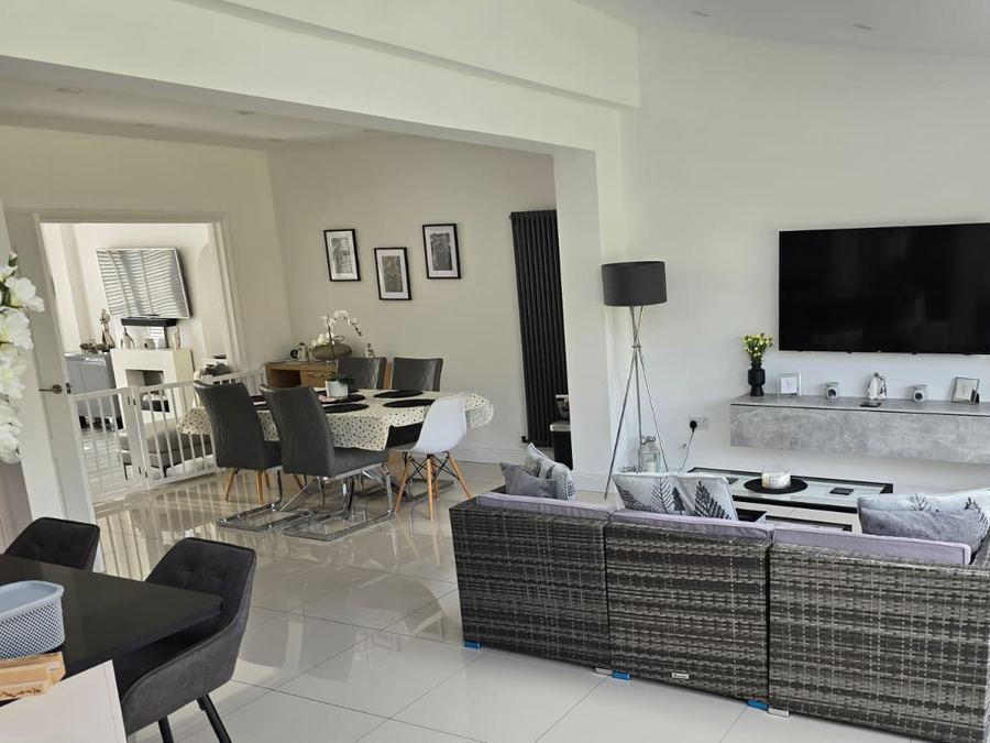 An open-plan living and dining space completed by GS Renovation, lit by a roof lantern
