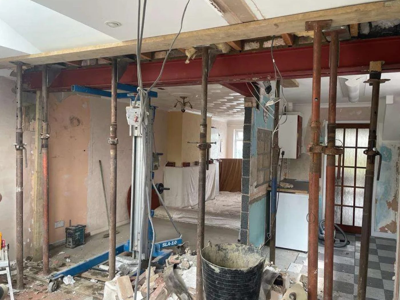 A red oxide steel beam installed by GS Renovation with the surrounding structure still propped