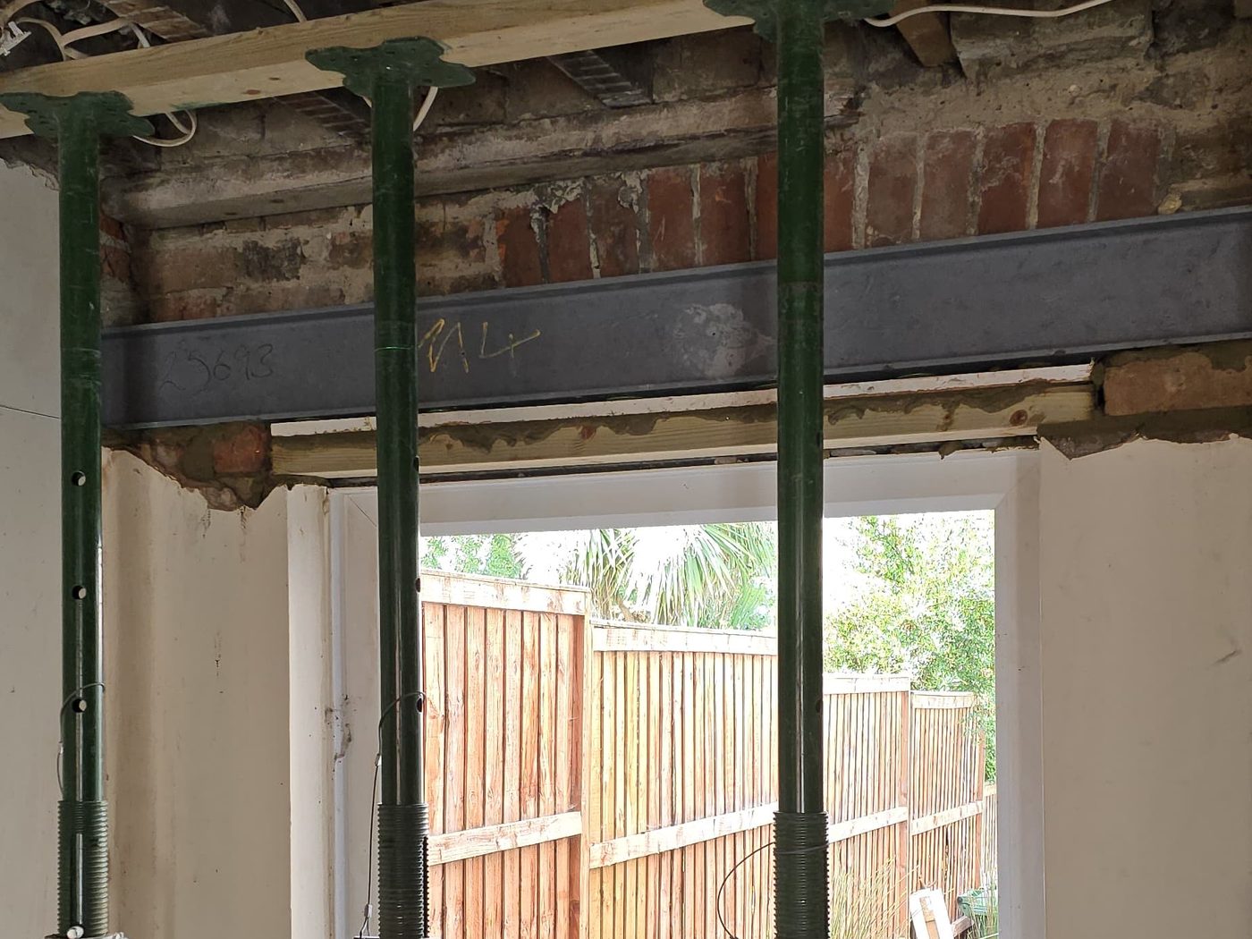 A steel beam installed by GS Renovation over a widened opening onto the garden, with the floor above still propped