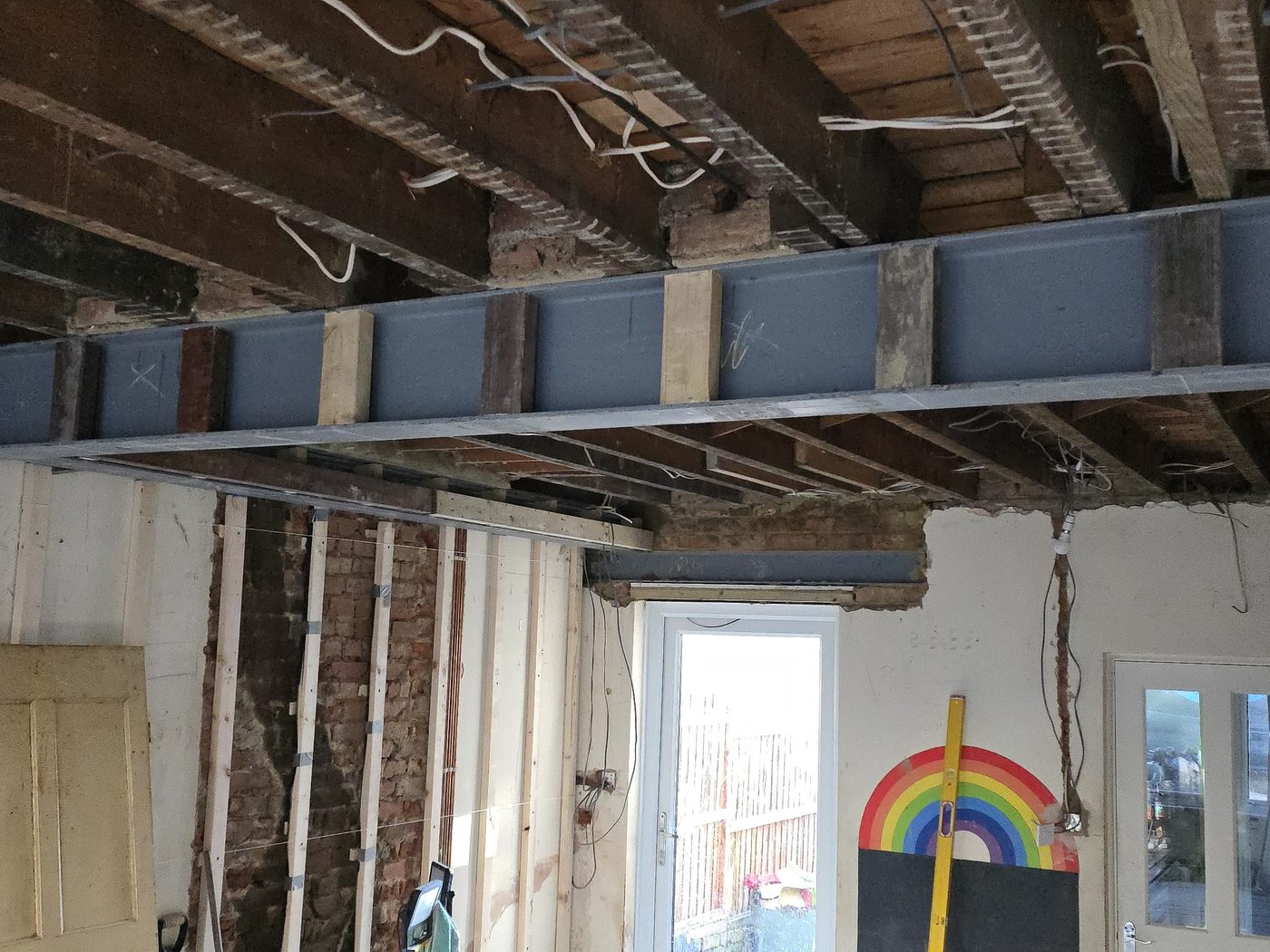 A steel beam spanning a stripped-out ground floor on a GS Renovation structural alteration